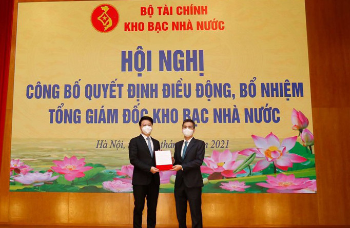 Thứ trưởng Bộ Tài Chính Võ Thành Hưng (phải) trao quyết định điều động cho ông Trần Quân hôm 10/8.